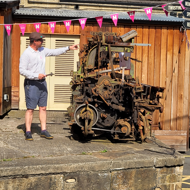 John Gaunt standing next to heritage machinery in the yard.