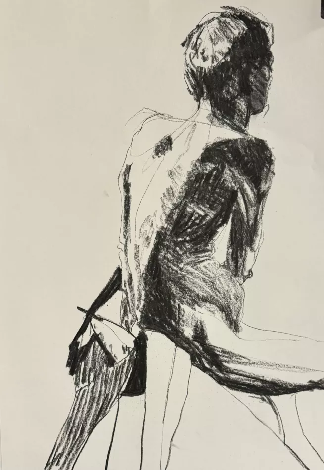 A charcoal study of  the back view of a male life model, showing shadow on one side of his body and light on the other side