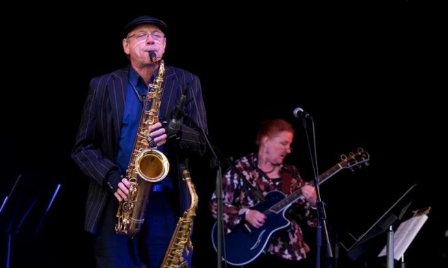 John Dyson playing saxophone, Kathy Dyson playing guitar