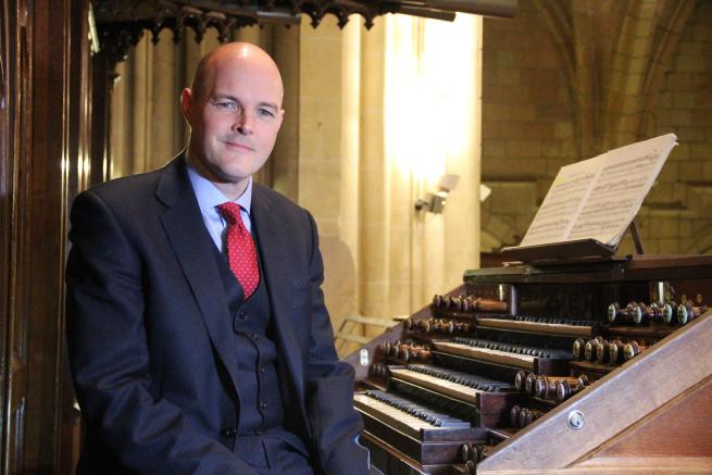 A musician sat at the organ console. 