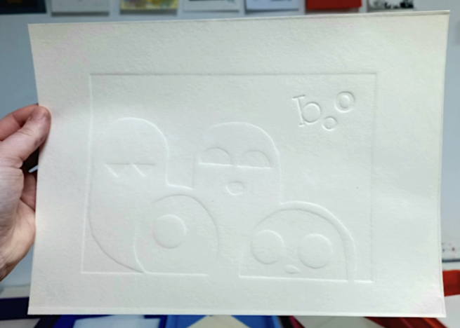 Embossed images of ghosts on white paper