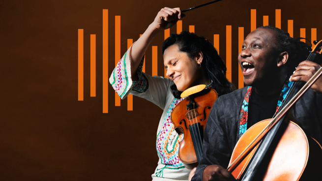 A young Welsh/Indian woman wearing a colourful, patterned top, her eyes are closed and she is smiling. She is holding a violin and has her left  arm in the air. She is next to a black man in his early 30s with long hair tied back and a dark coloured top with colourful collar. He is smiling and holding a cello.