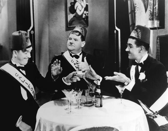 A black and white still from Sons Of The Desert featuring Stan Laurel, Oliver Hardy and Charley Chase,.