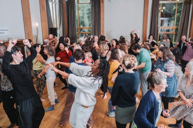 A room full of people dancing and singing