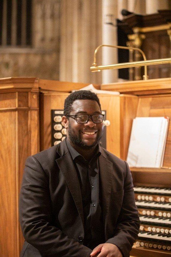 A musician sat on the organ bench. 