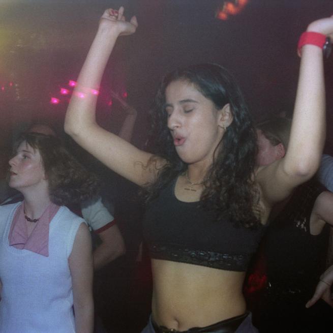 Woman with hands in the air at The Orbit club, 1994