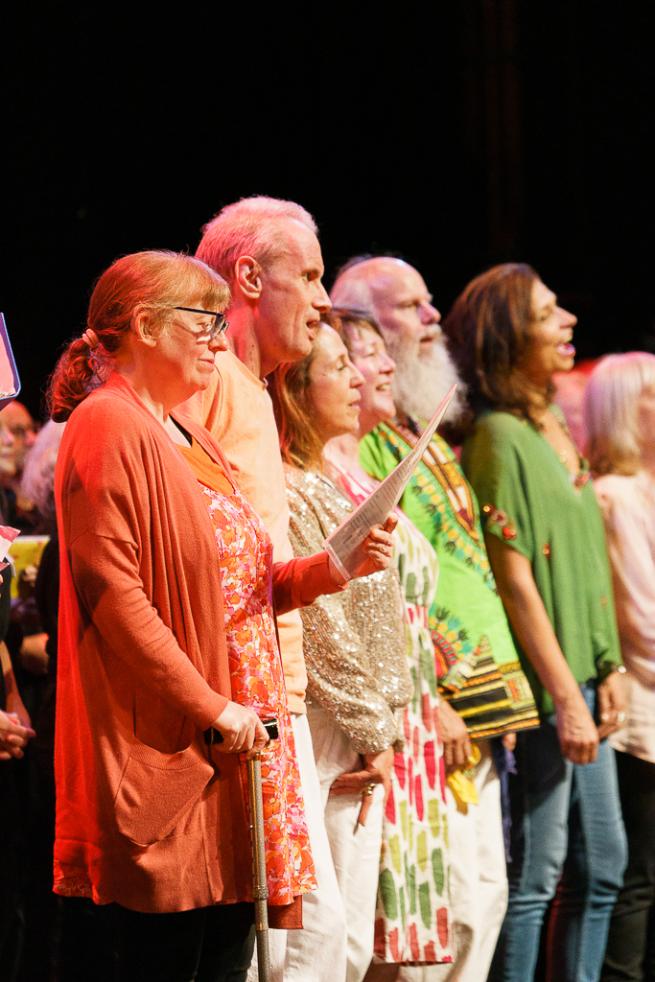 a group of adults singing on stage 