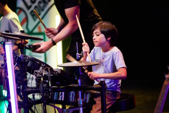 A boy playing a drum kit