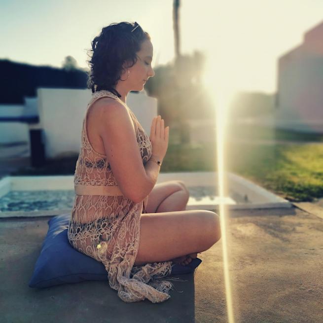 Yoga Teacher Sarah Ord sitting on a cushion in meditation