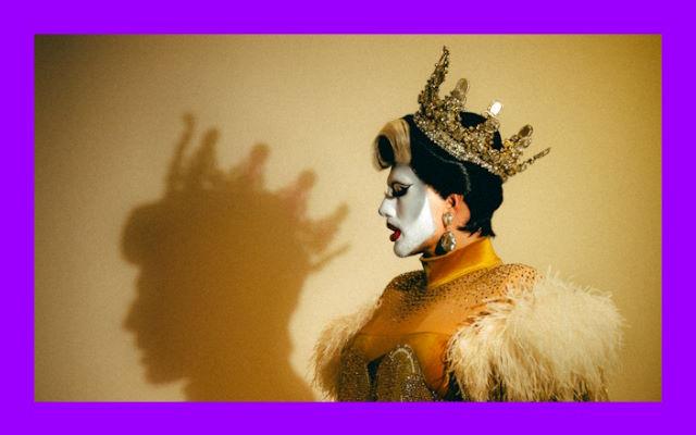 A person wearing a crown, their shadow is projected against the wall.