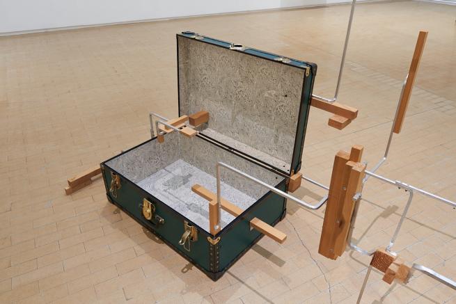 An artwork made from a suitcase with added metal and wood parts