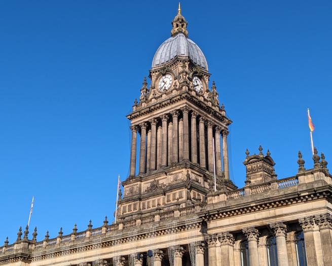 The clock tower of Leeds Town Hall against a backdrop of clear blue sky