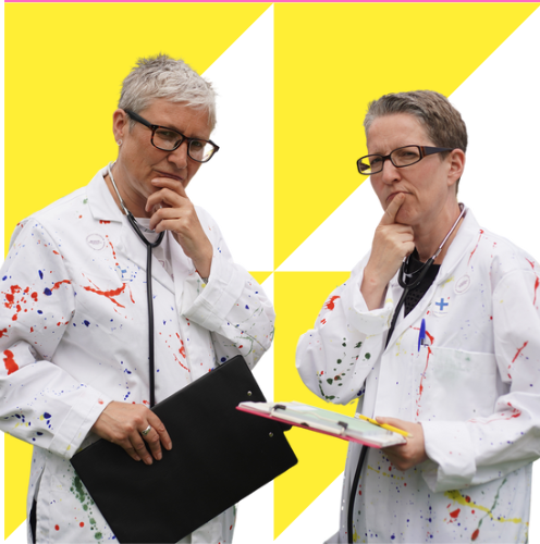 Two artists dressed in doctors white coats splashed with paint