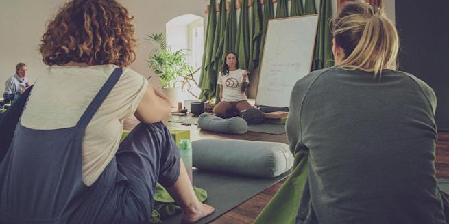 Erica leading a workshop, speaking to a circle of people