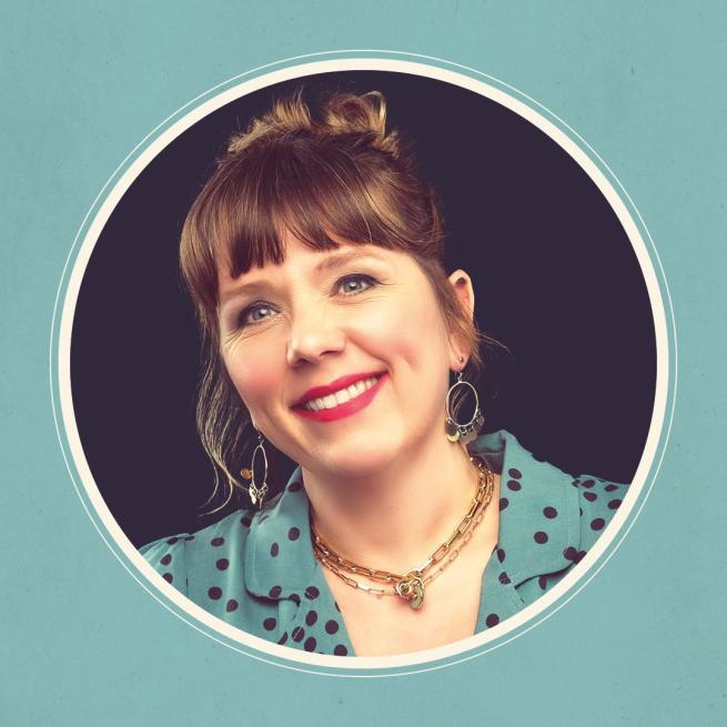 Headshot of Kerry Godliman wearing a teal blouse with black polka dots, big necklace and earrings. Photo is in a circular frame.