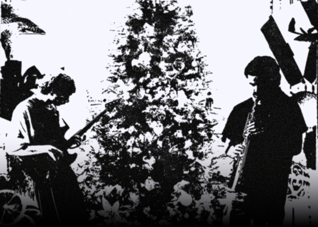 bass player (left) and soprano saxophone player (right) stood infront of a christmas tree, surrounded by christmas ornaments in black and white