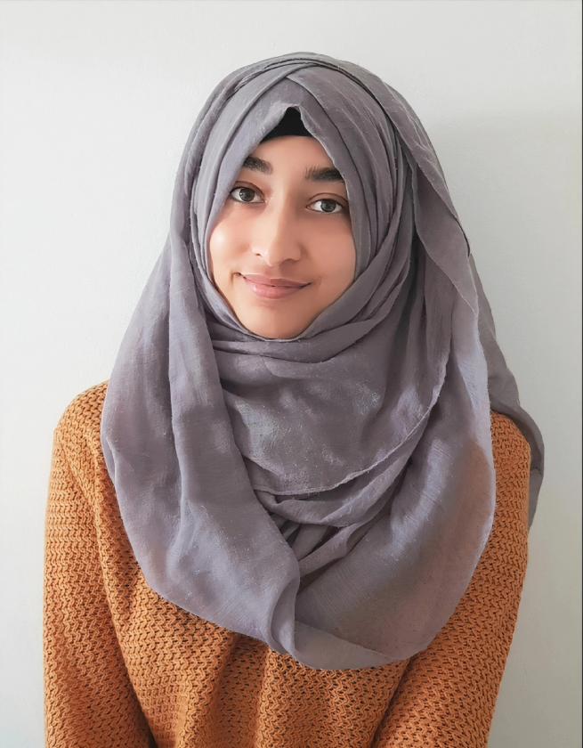 Photographic portrait of children's author Burhana Islam wearing an orange jumper and grey headscarf