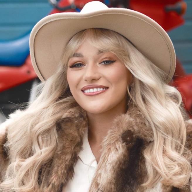 Claudia Buckley wearing a beige cowboy hat and a fur coat.