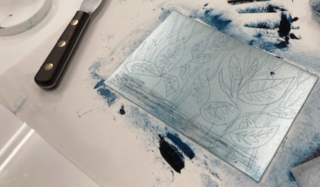 An etched metal plate with images of leaves