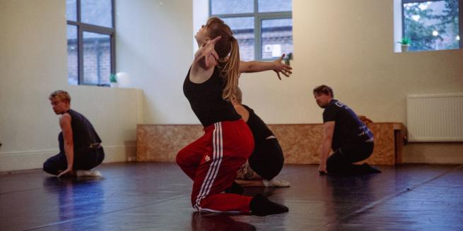 4 dancers on crouched on the floor