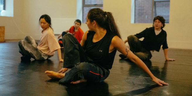 4 dancers crouched on the floor