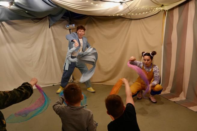 Two actors twirl ribbons for a young audience