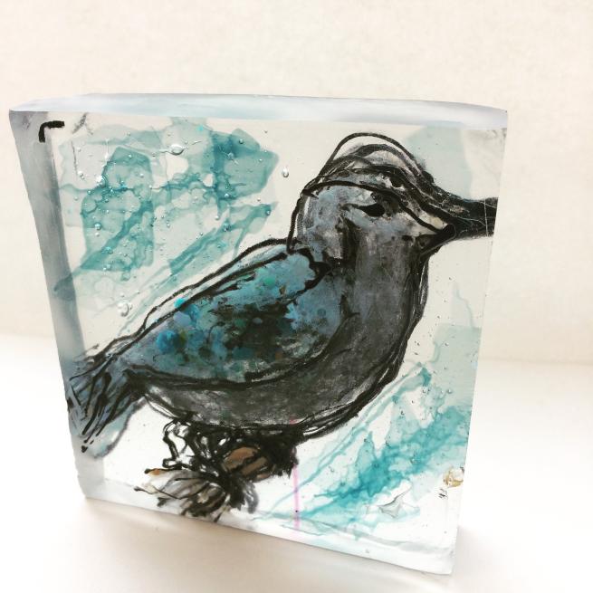 A painting of a bird in a block of glass.