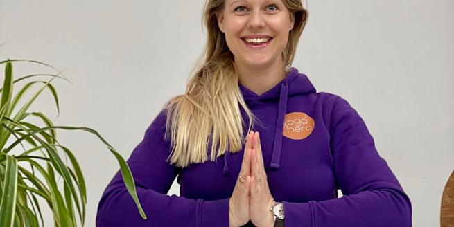 Yoga Teacher Holly smiling with hands in prayer position