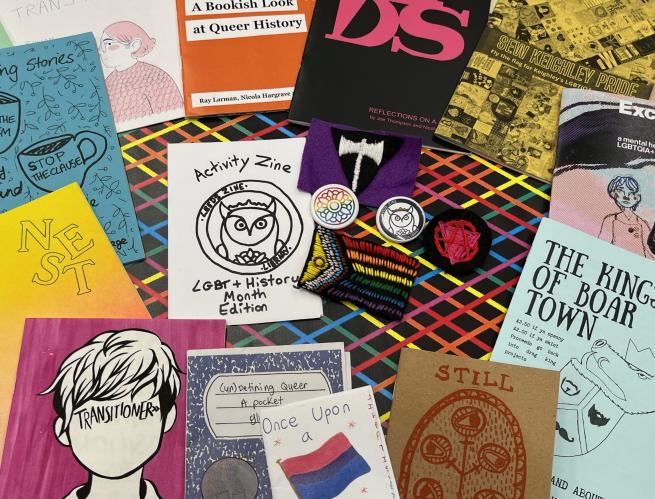 LGBTQ+ zines with badges and patches