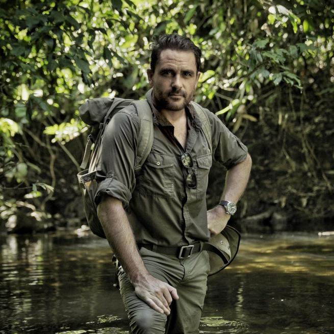 Levison Wood stood in a rainforest pool in all khaki with his left hand on his hip.