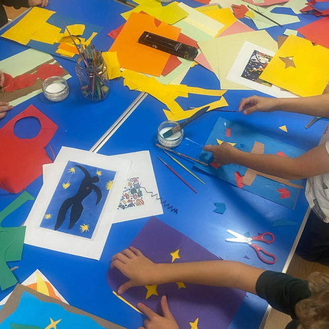 Children's craft workshop with coloured paper and scissors.