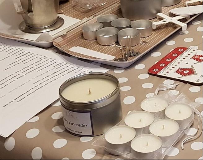 Candles and the equipment used on make candles on a spotted tablecloth