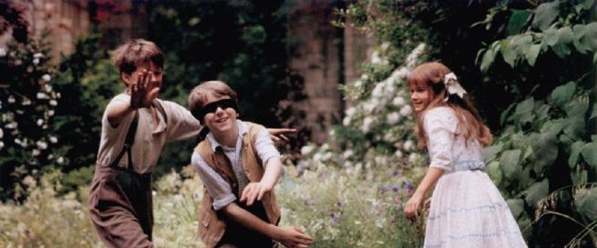 Two boys and a young girl play in a garden