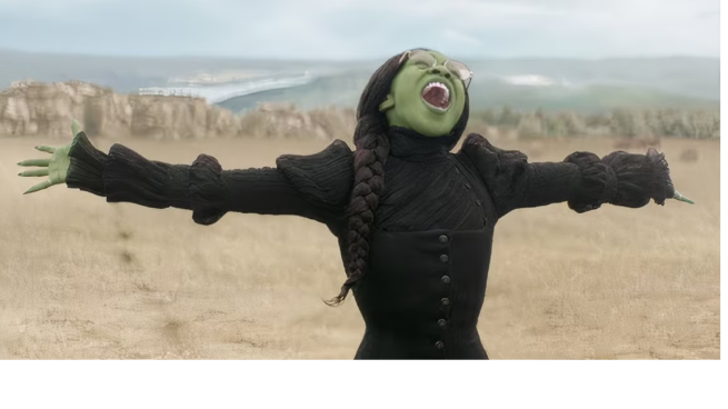 Elphaba (a green skined woman) sings with her arms outstretched