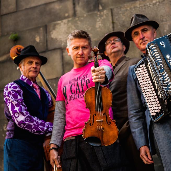 Budapest Cafe Orchestra press shot where they're all holding their instruments.