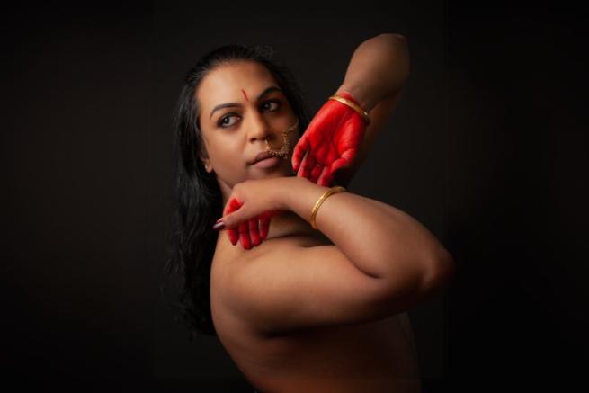 A person with red painted hands in a dynamic pose