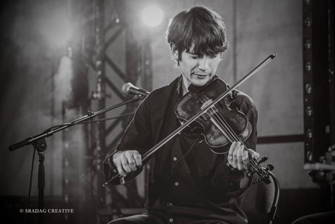 Black and white image of Ryan playing the fiddle.