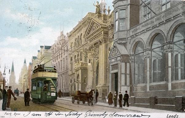 An image of Park Row in Leeds (1903) with a tram going past elegant Victorian buildings.