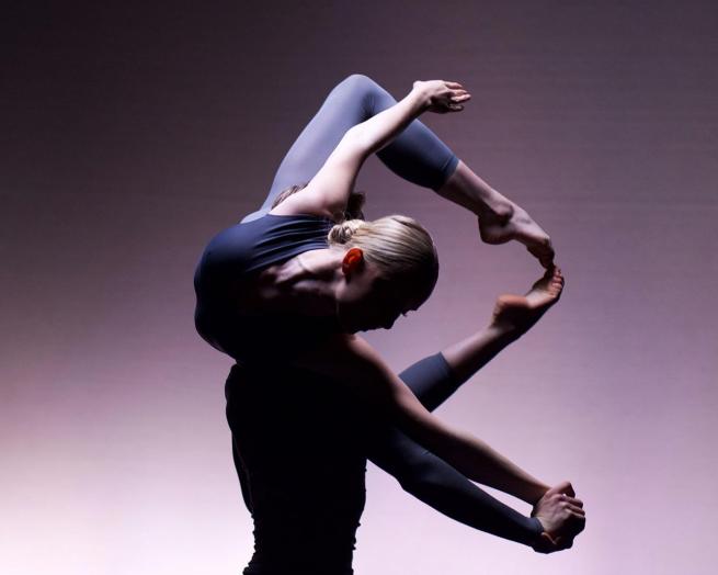 A dancer poses in an arched position while being lifted