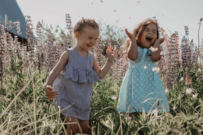 Two girls having fun in a wildflower field