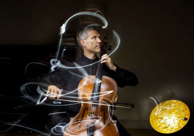 An image of Matthew Barley playing a cello with swirls of light trails around him