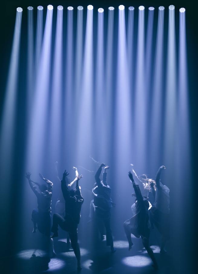Dancers on stage with spotlights