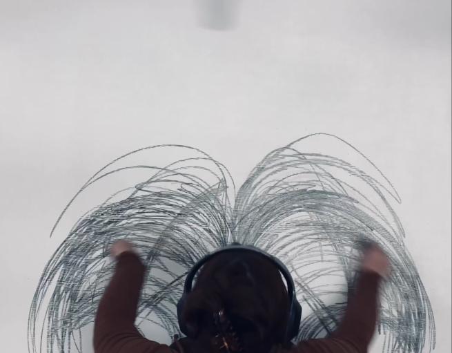 A person wearing headphones draws in expressive arcs.