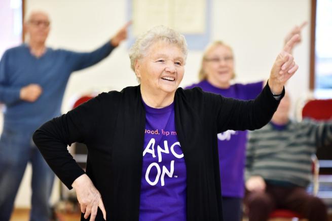 A lady is dancing with a big smile