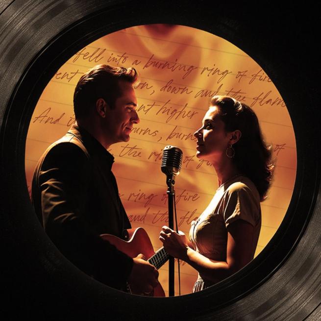 Two actors portraying Johnny Cash and June Carter stand in profile as they share a microphone. The are in golden light in front of a lyrics sheet, and framed by a large vinyl record. 