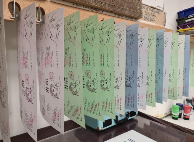 Screen printed pages from a zine drying in a marble drying rack