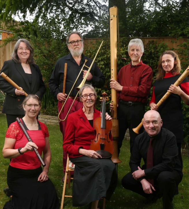 A group of jolly troubadors holdingan array of medieval instruments