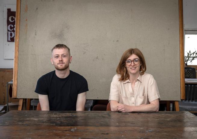 Two people sat at a desk