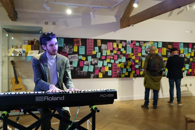 Man playing the keyboard within a museum.