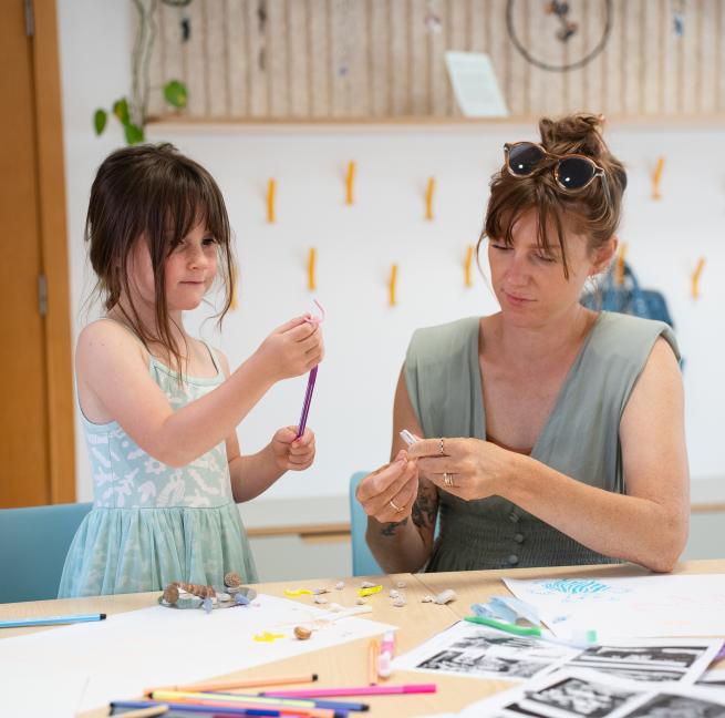 A mother and daughter make crafts together 